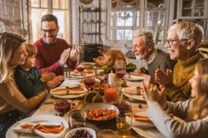 multigenerational-family-gathered-around-the-table-at-thanksgiving